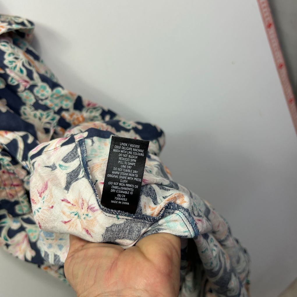 Navy floral blouse detail view showing fabric and label