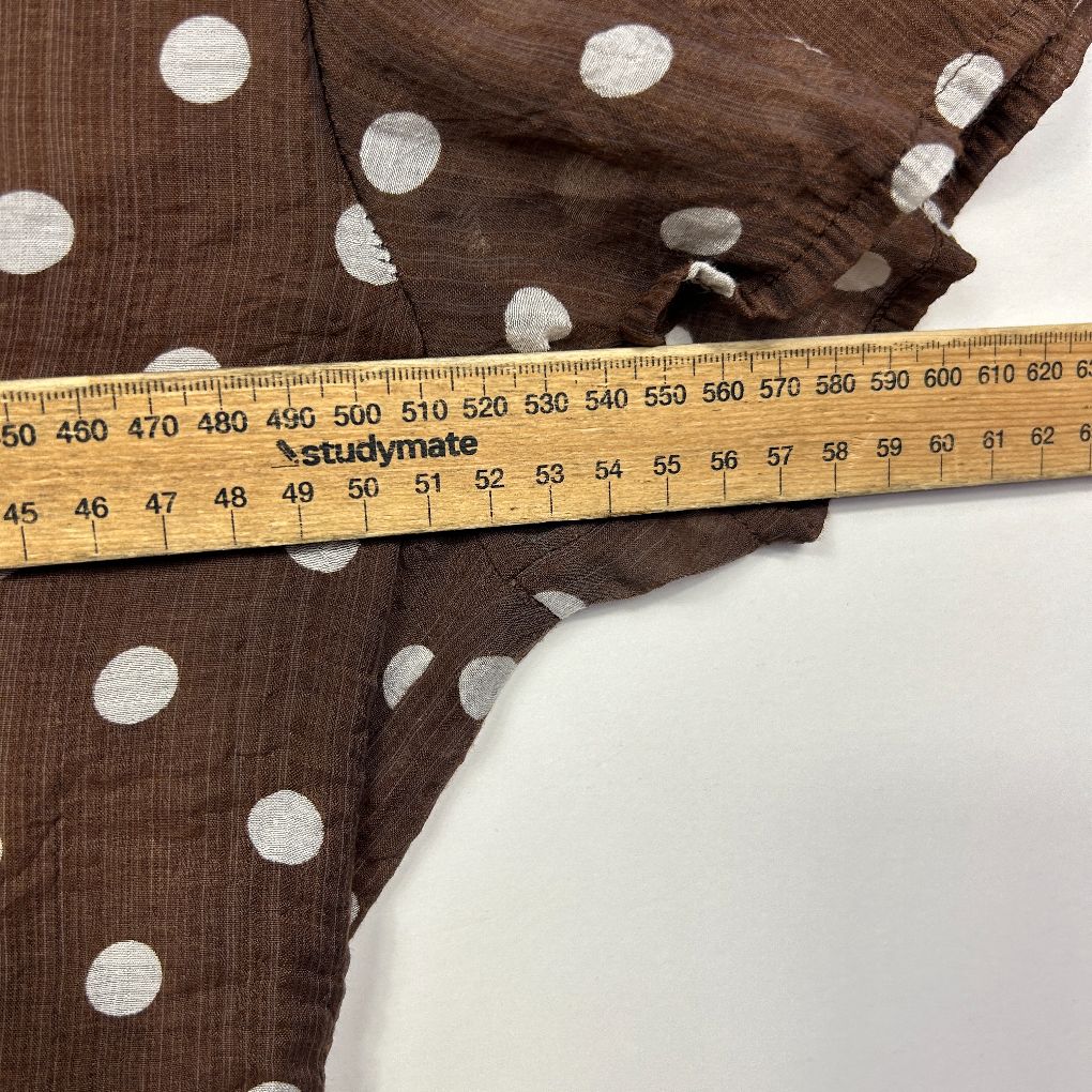 Brown polka dot fabric with measuring tape detail view
