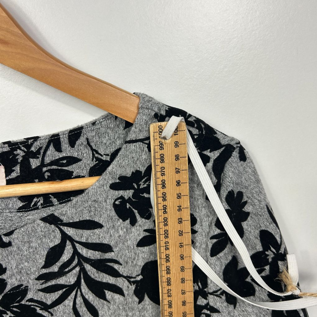 Grey and black floral top detail view with measuring tape