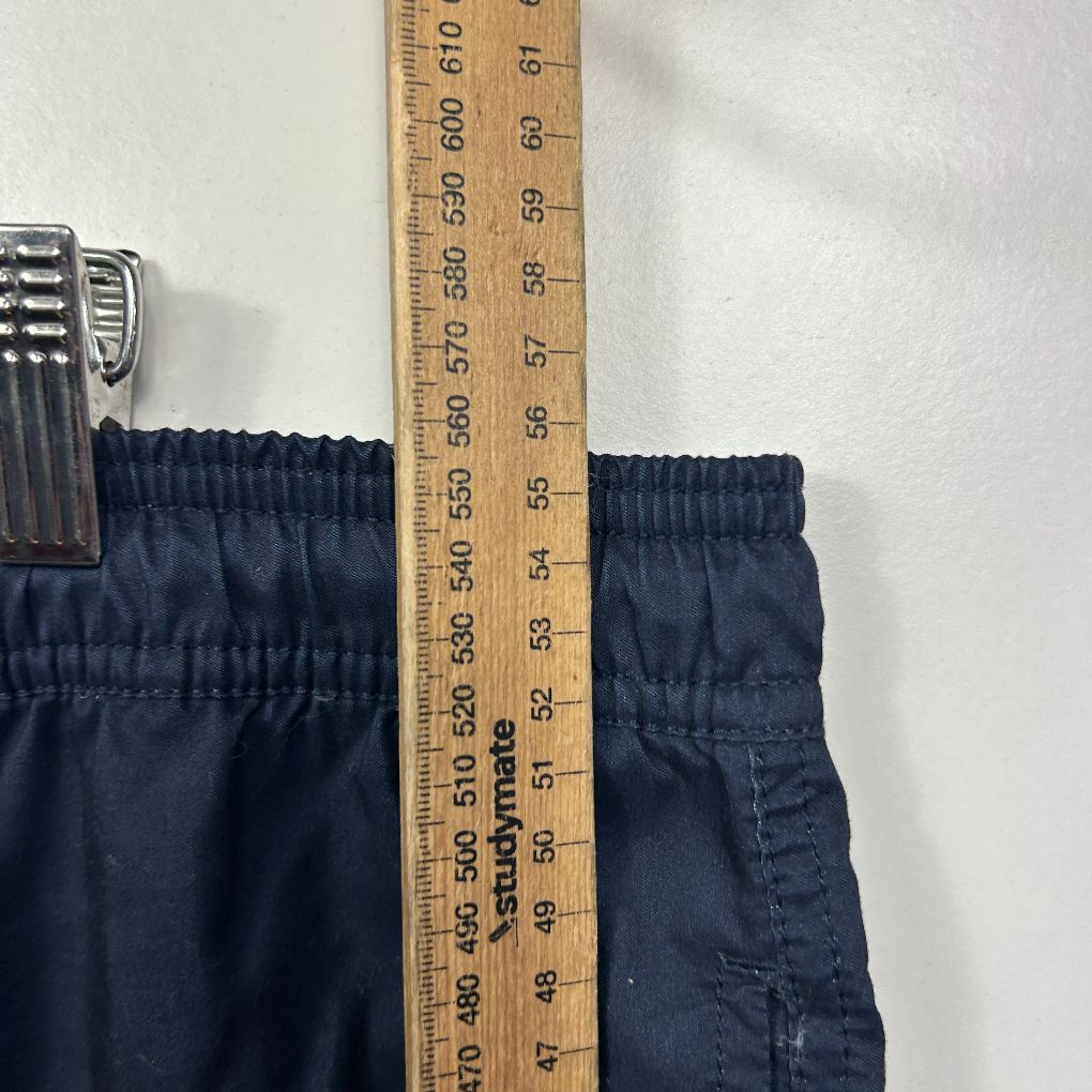 Navy shorts waistband detail view with measuring tape
