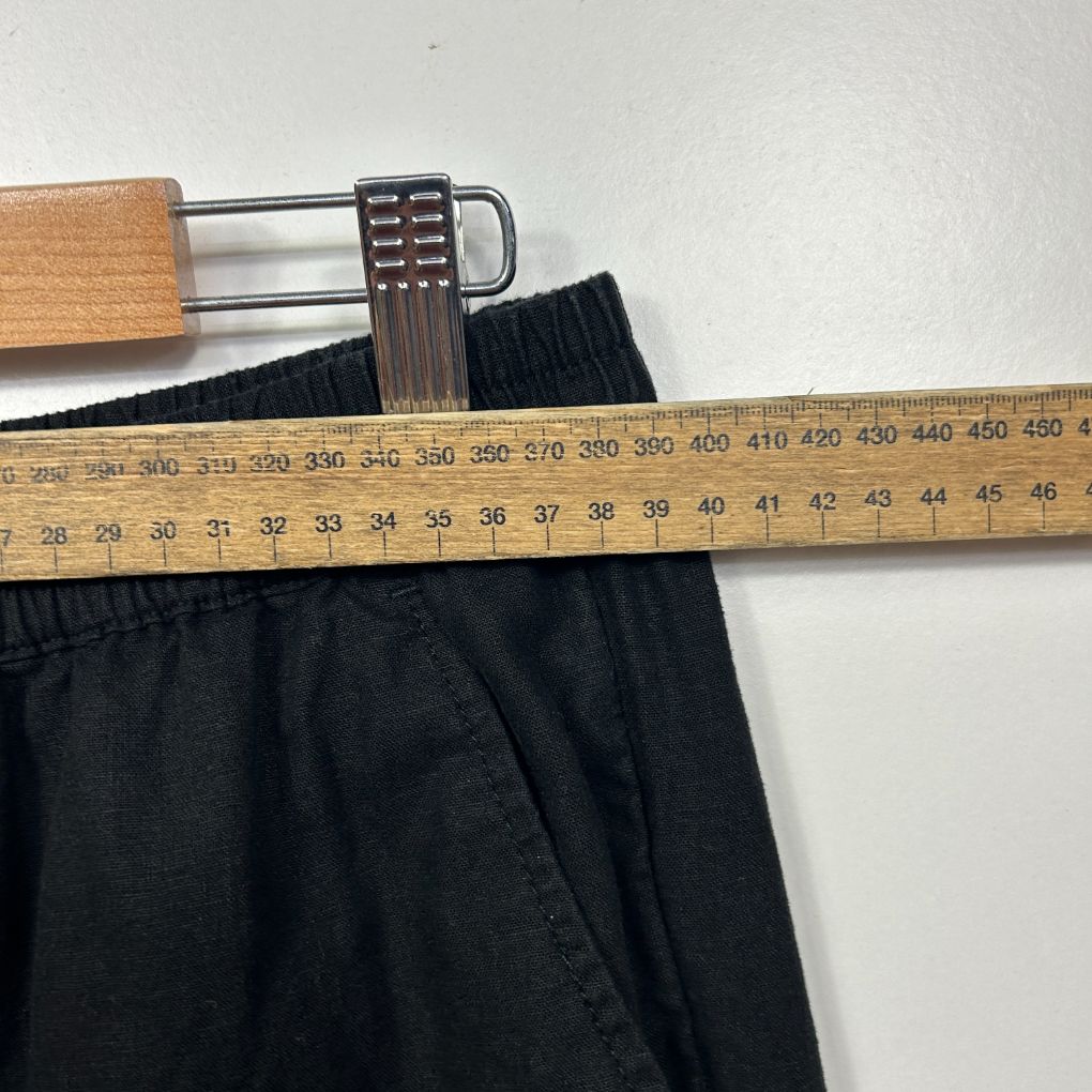 Black shorts waistband detail view with measuring tape