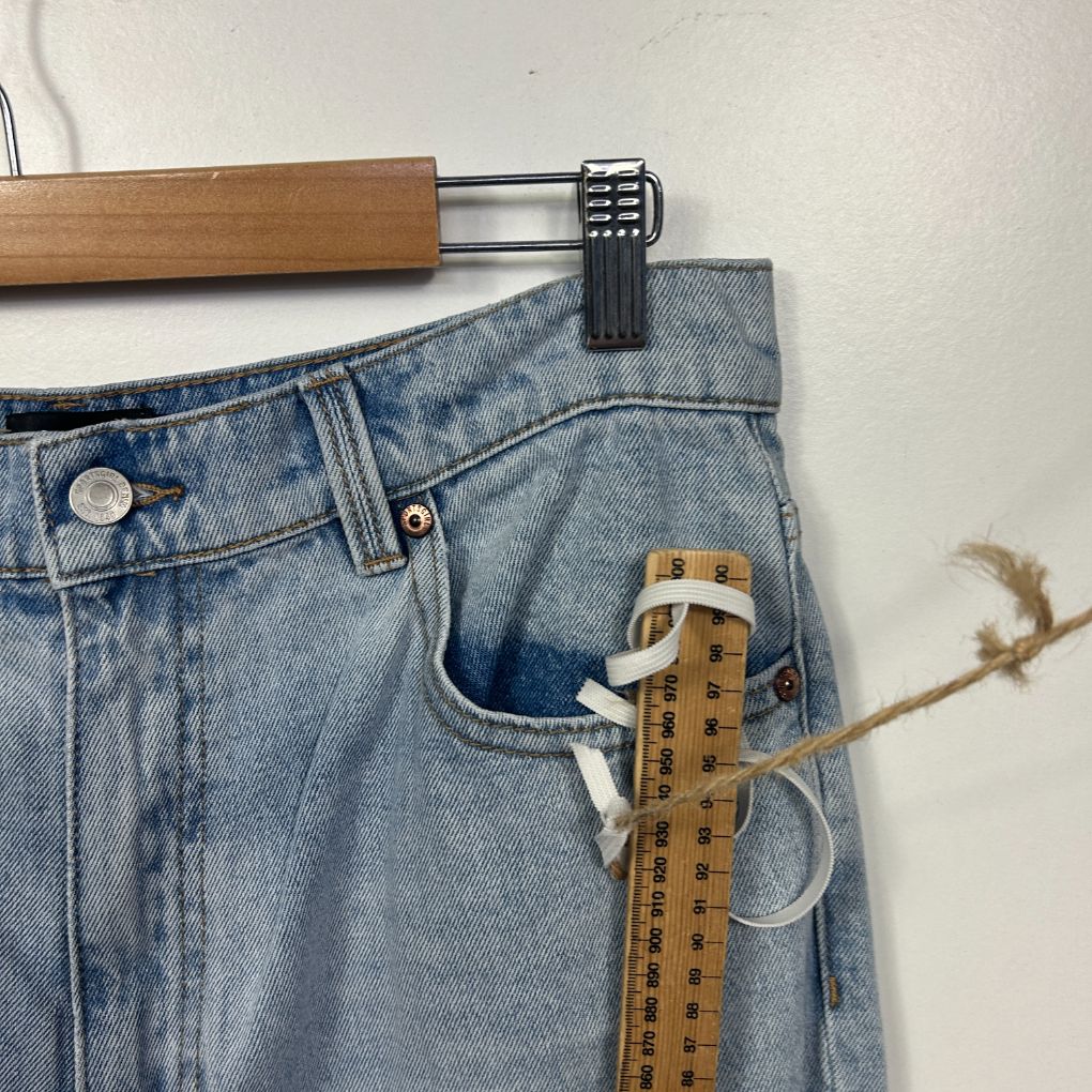 Light blue denim jeans front view with measuring tape