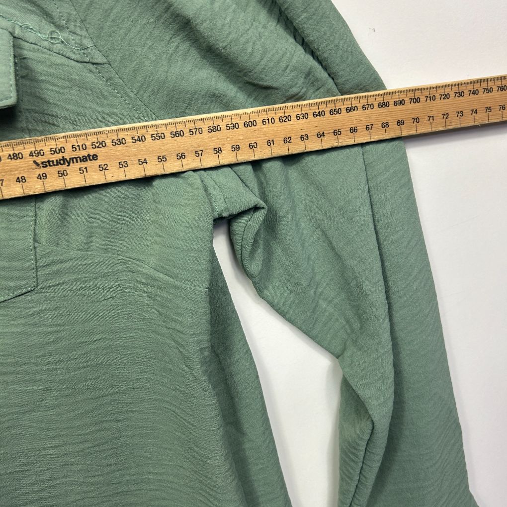 Green shirt detail view with measuring tape
