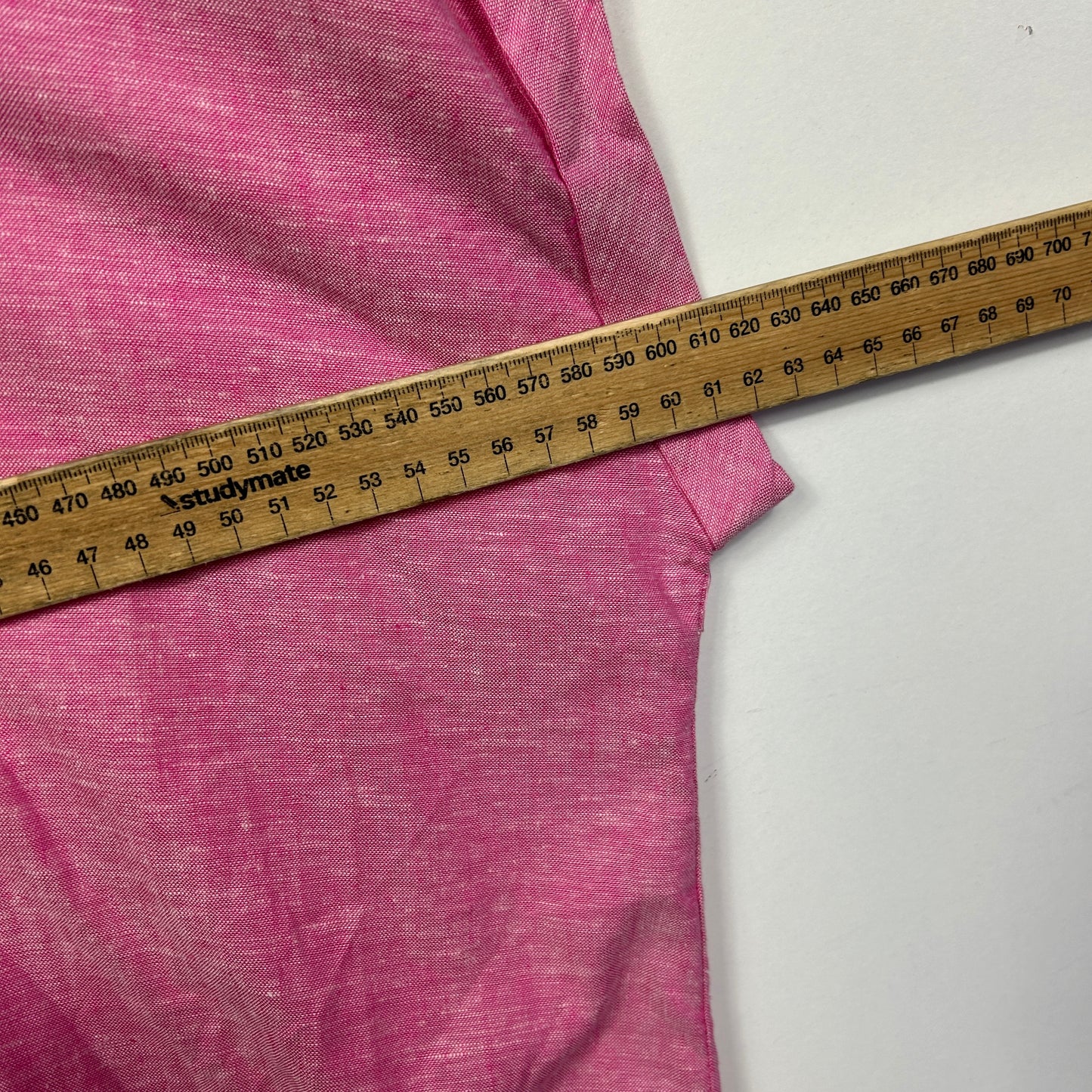 Pink t-shirt being measured with a tape measure detail view