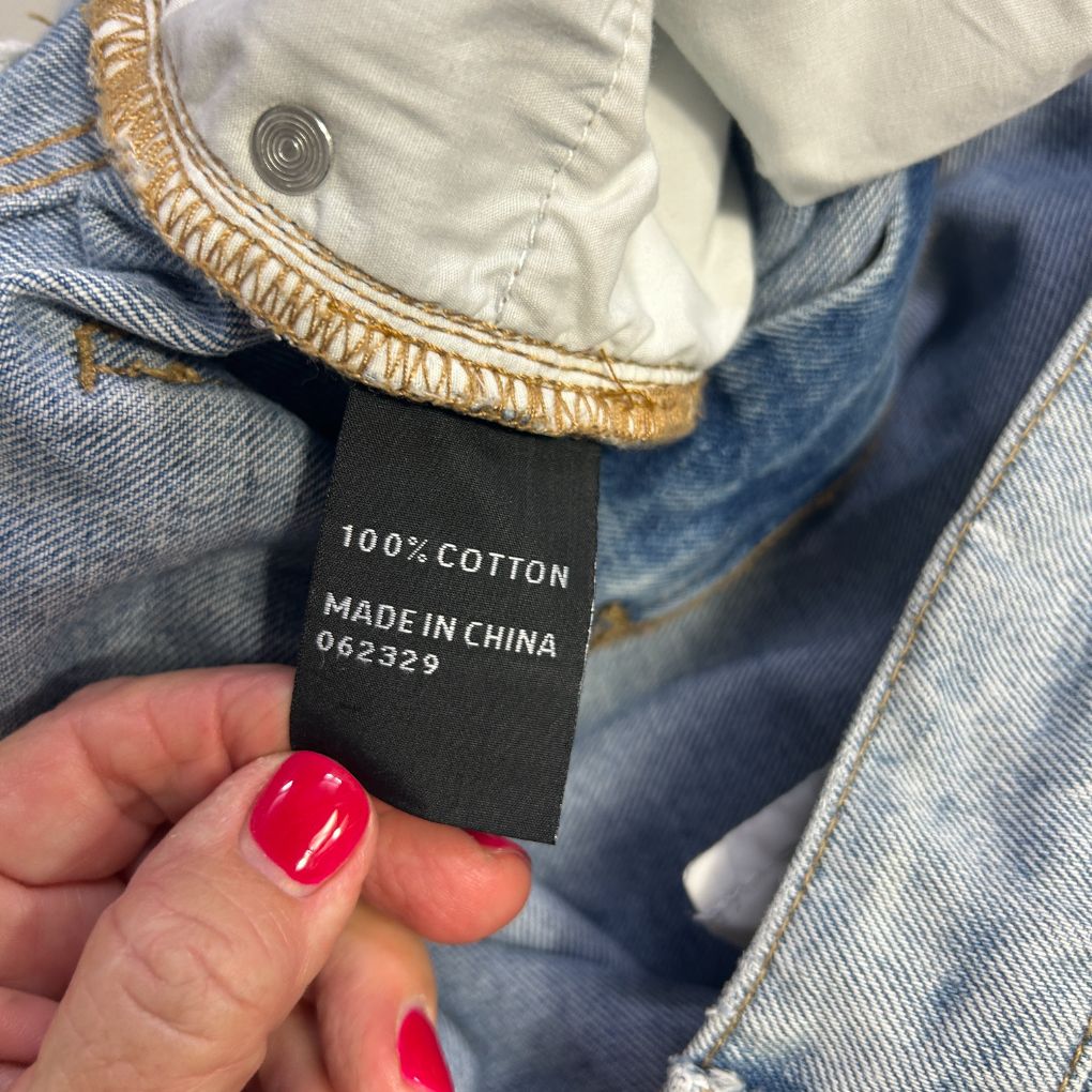 Blue denim jacket label detail showing 100% cotton and made in China