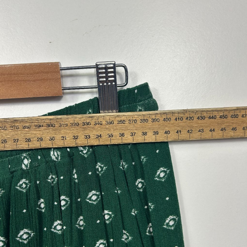 Green floral dress with measuring tape detail view