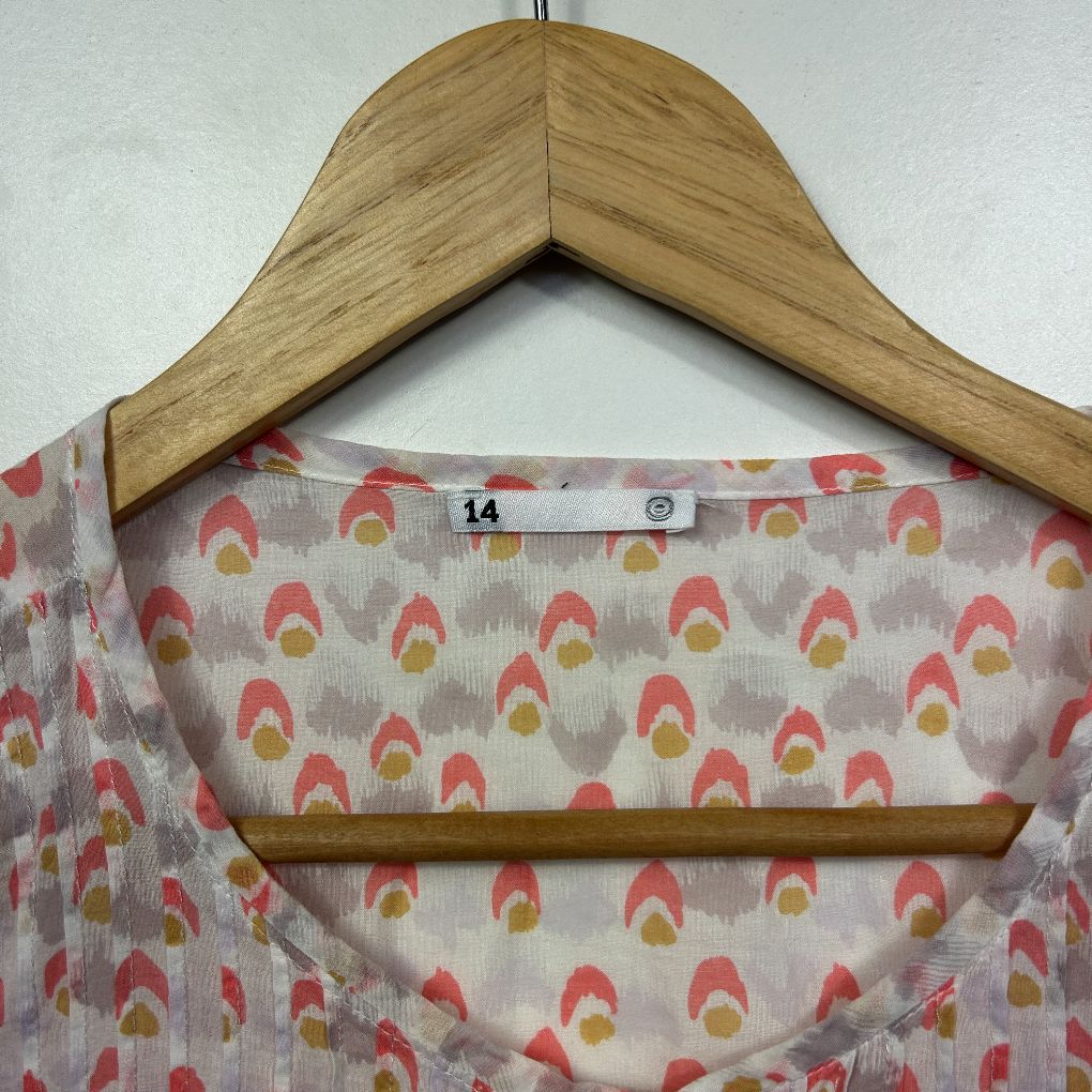 Pink floral print top on wooden hanger detail view