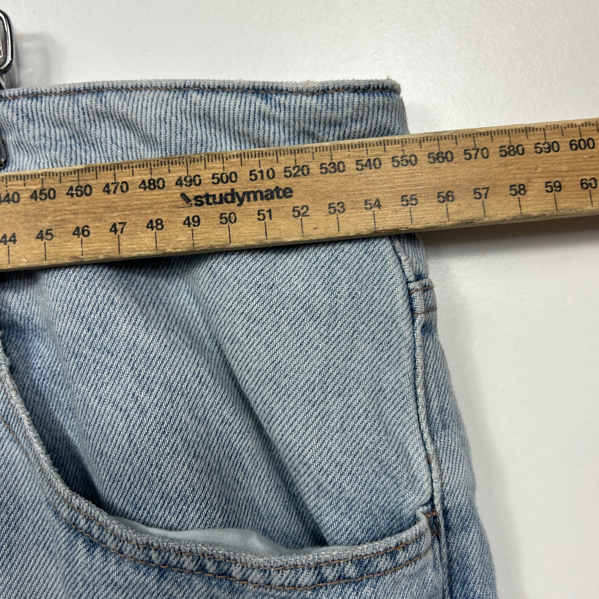 Light blue striped jeans detail view with measuring tape