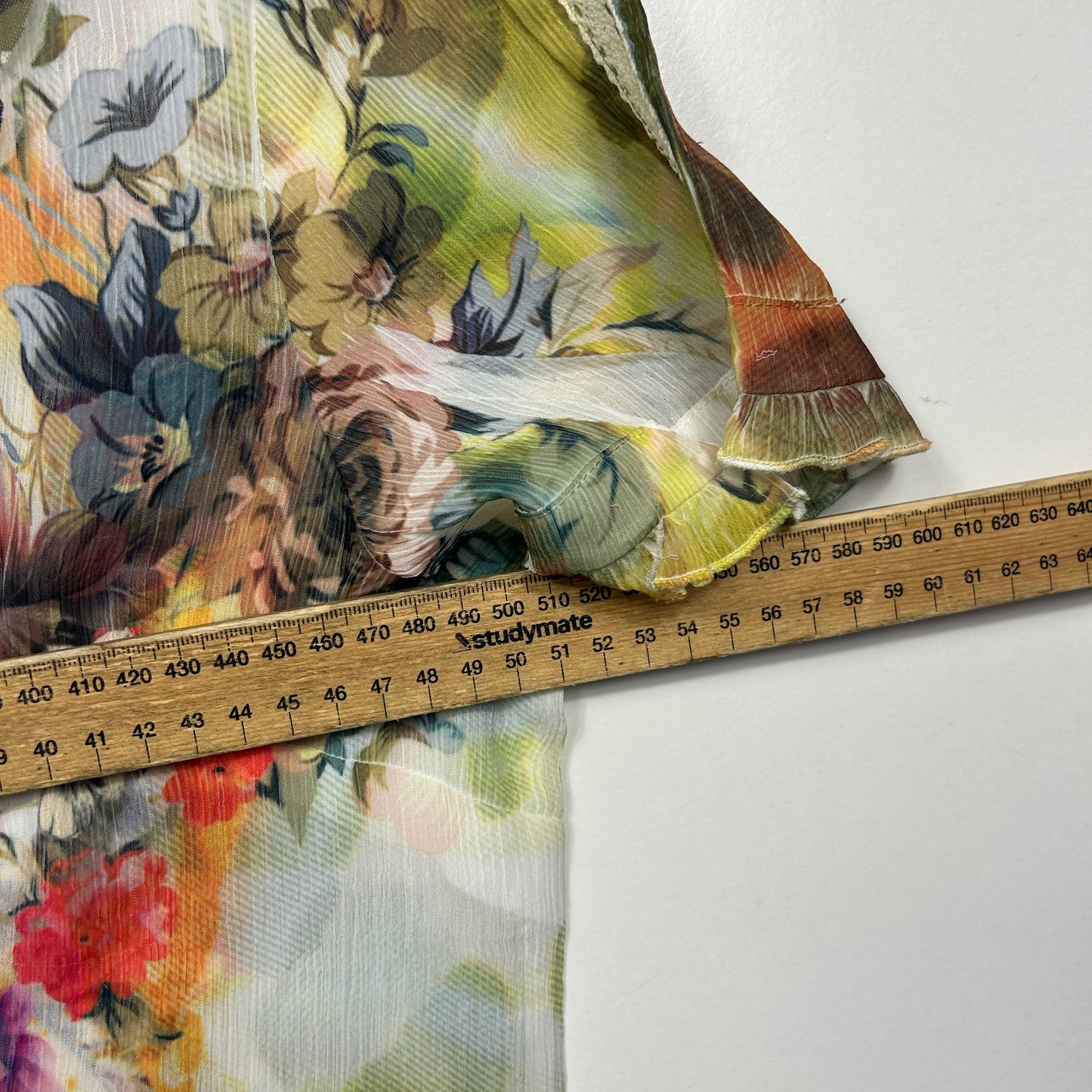 Multicoloured floral fabric detail view with measuring tape