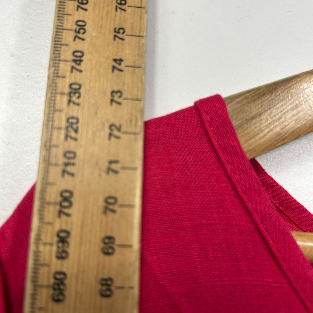 Red fabric close-up detail view with wooden measuring ruler