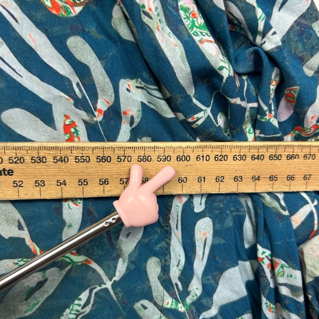 Blue fabric with white striped and floral pattern, measuring tape detail view