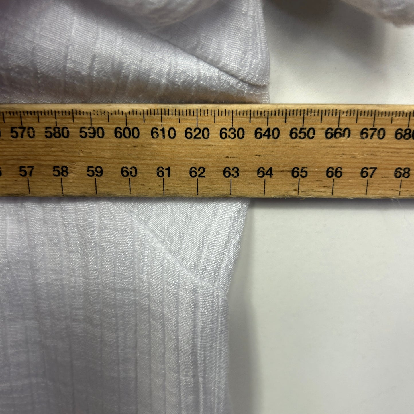 Light grey fabric detail view with measuring tape