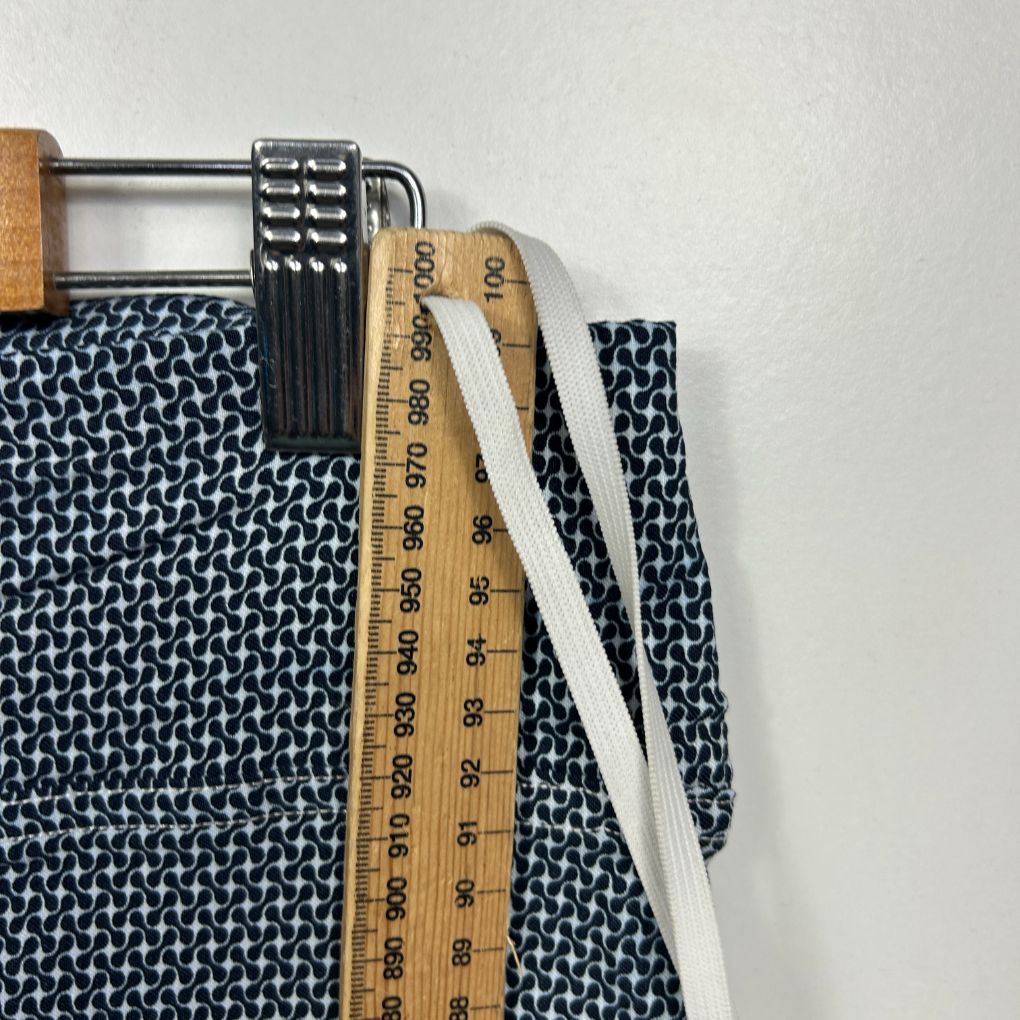 Navy and white geometric patterned fabric with measuring tape and wooden handles detail view