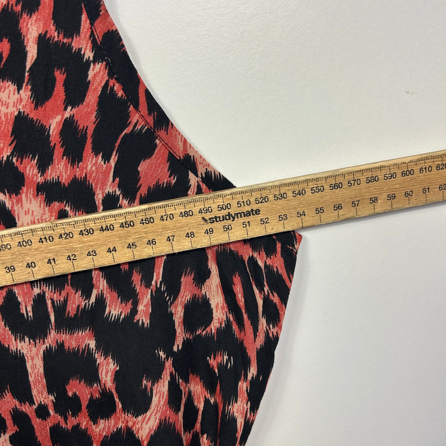 Red and black leopard print fabric detail view with measuring tape