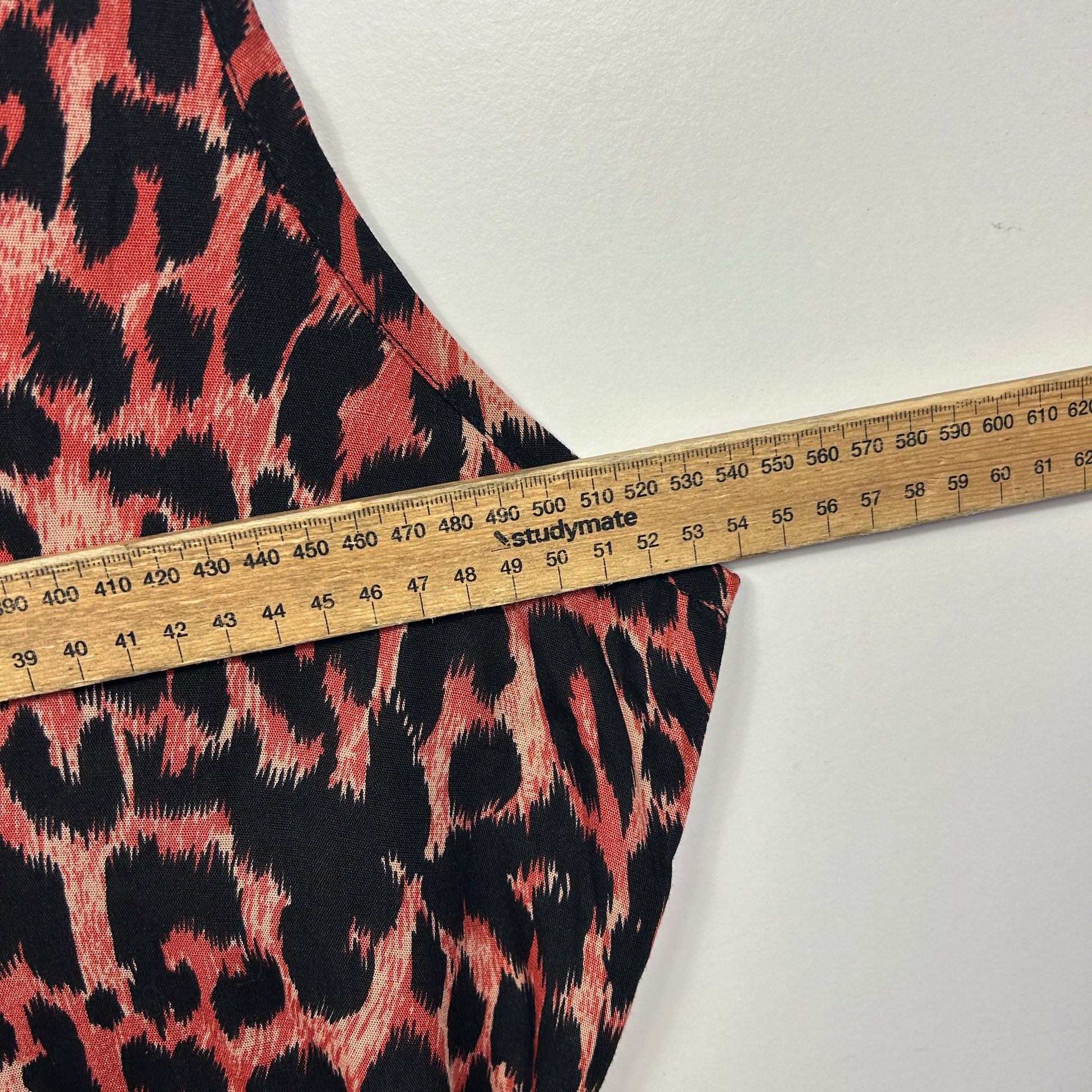 Red and black leopard print fabric detail view with measuring tape
