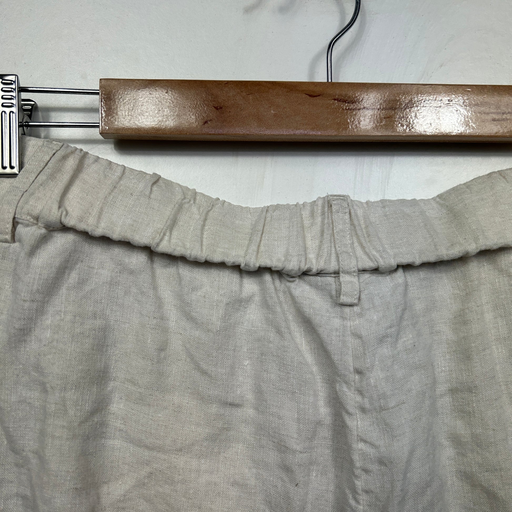 Beige linen pants front view on wooden hanger