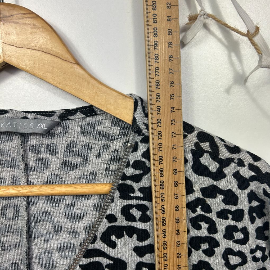 Grey and black leopard print top detail view on hanger with measuring tape