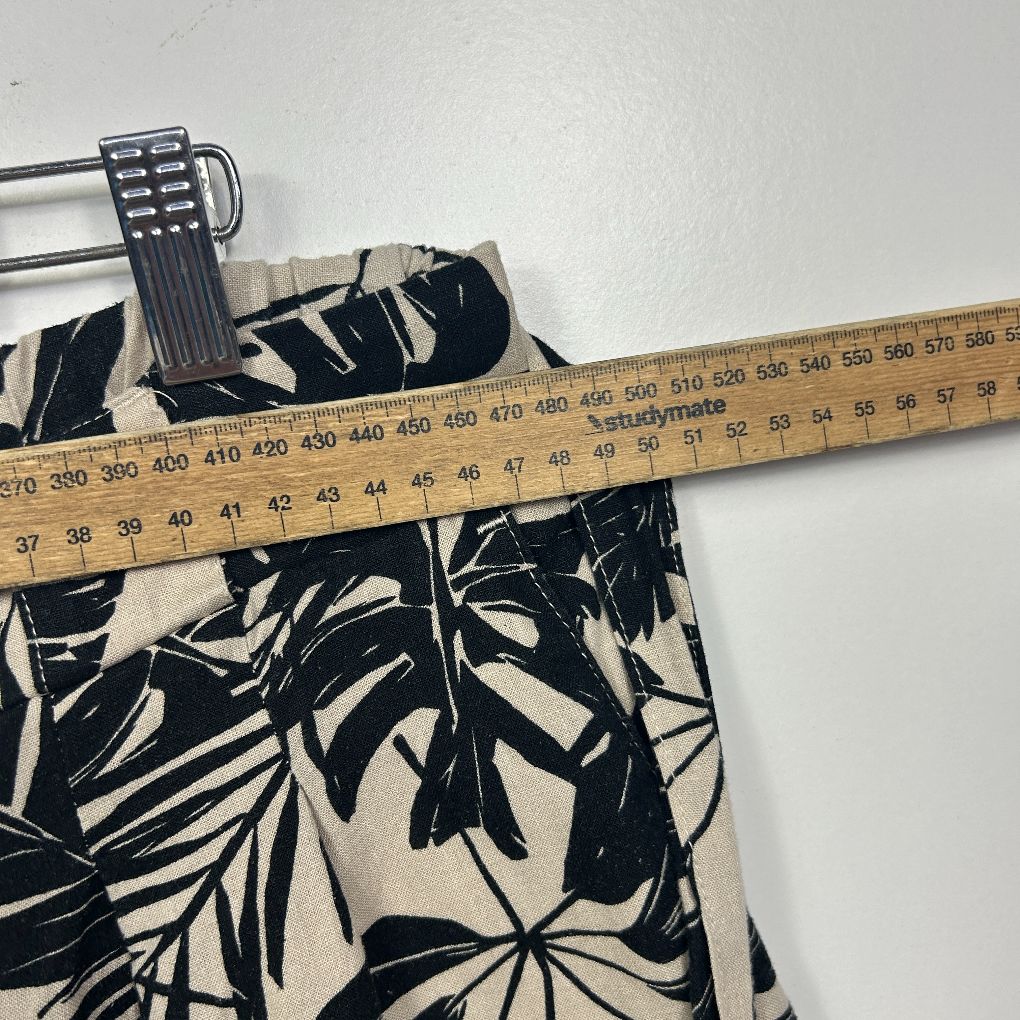 Cream and black floral print shorts detail view with measuring tape