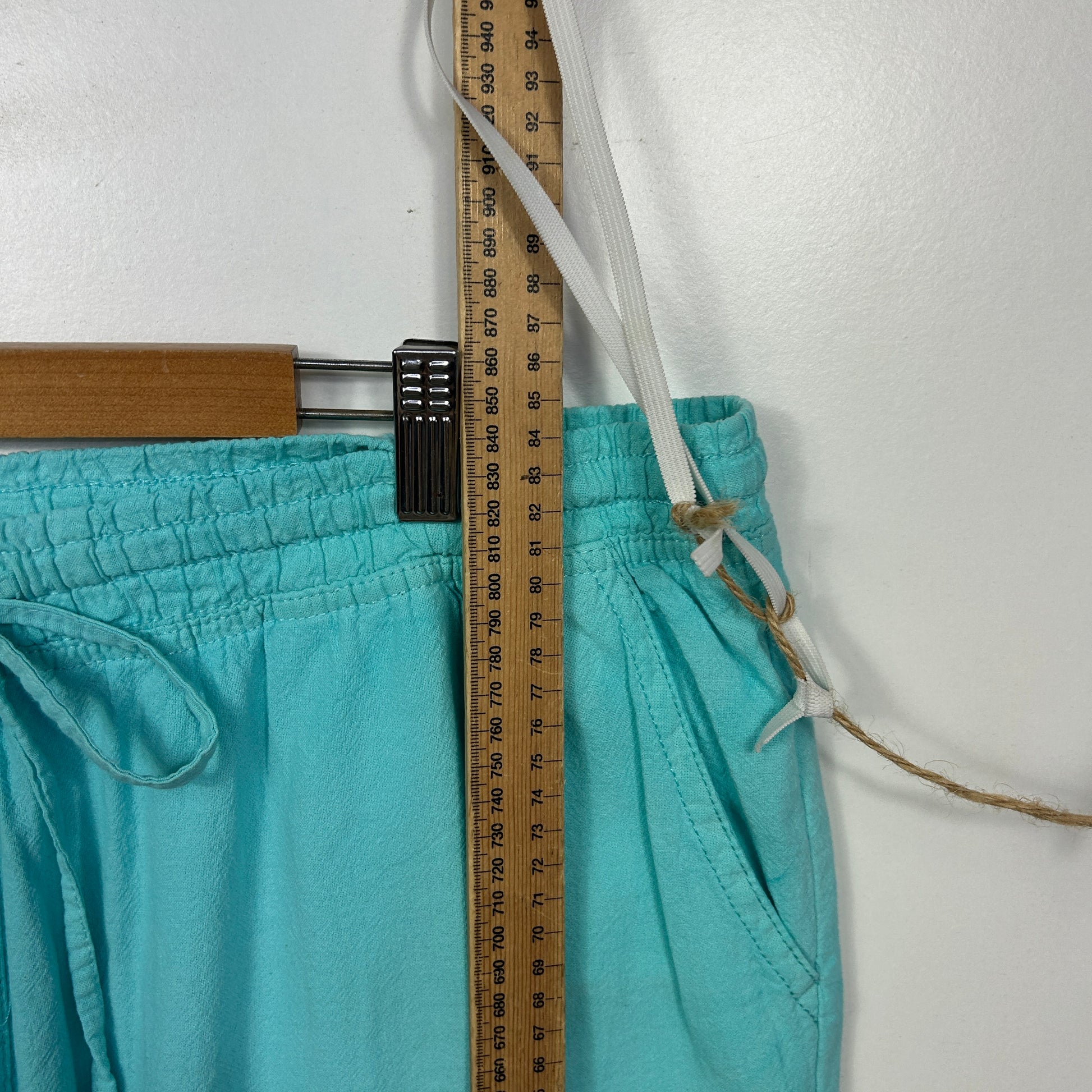 Turquoise shorts detail view with measuring tape