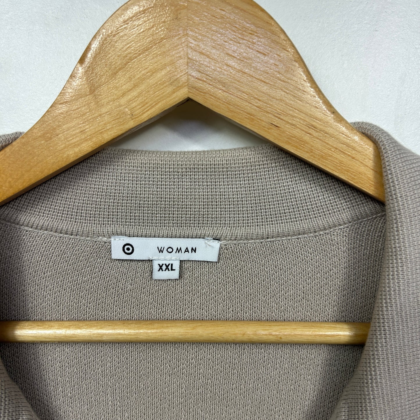 Beige knit sweater front view on wooden hanger