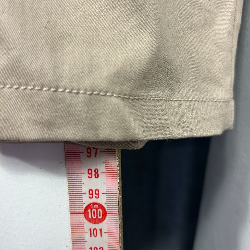Beige garment detail view with measurement tape