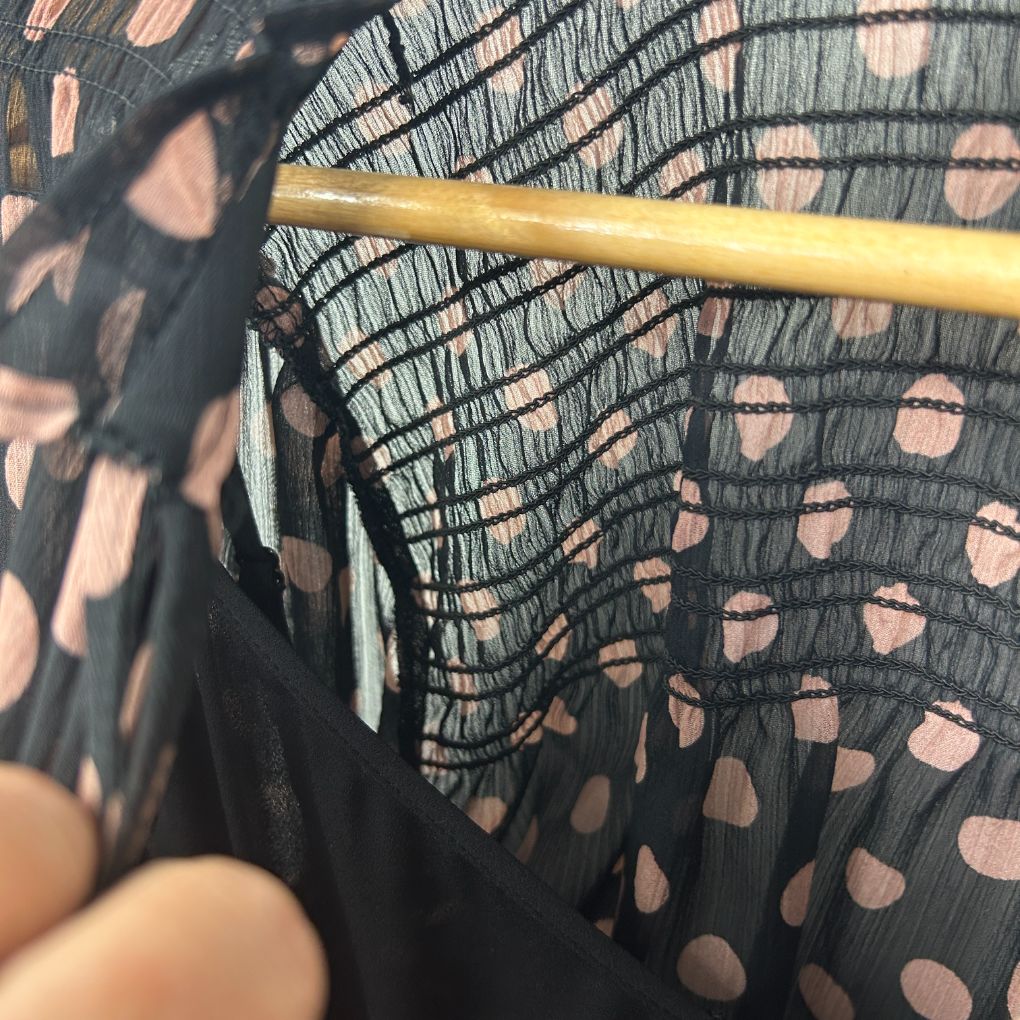 Black mesh top with polka dot pattern detail view