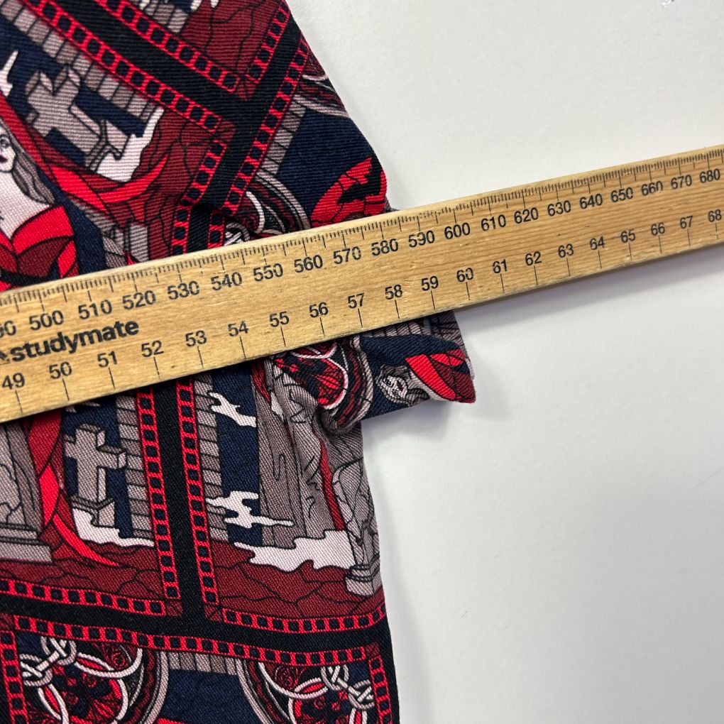 Red and navy graphic print shirt detail view with measuring tape