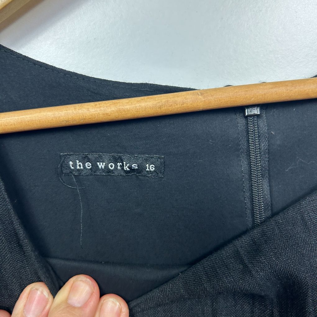 Black pants label detail view showing the works brand tag size 16