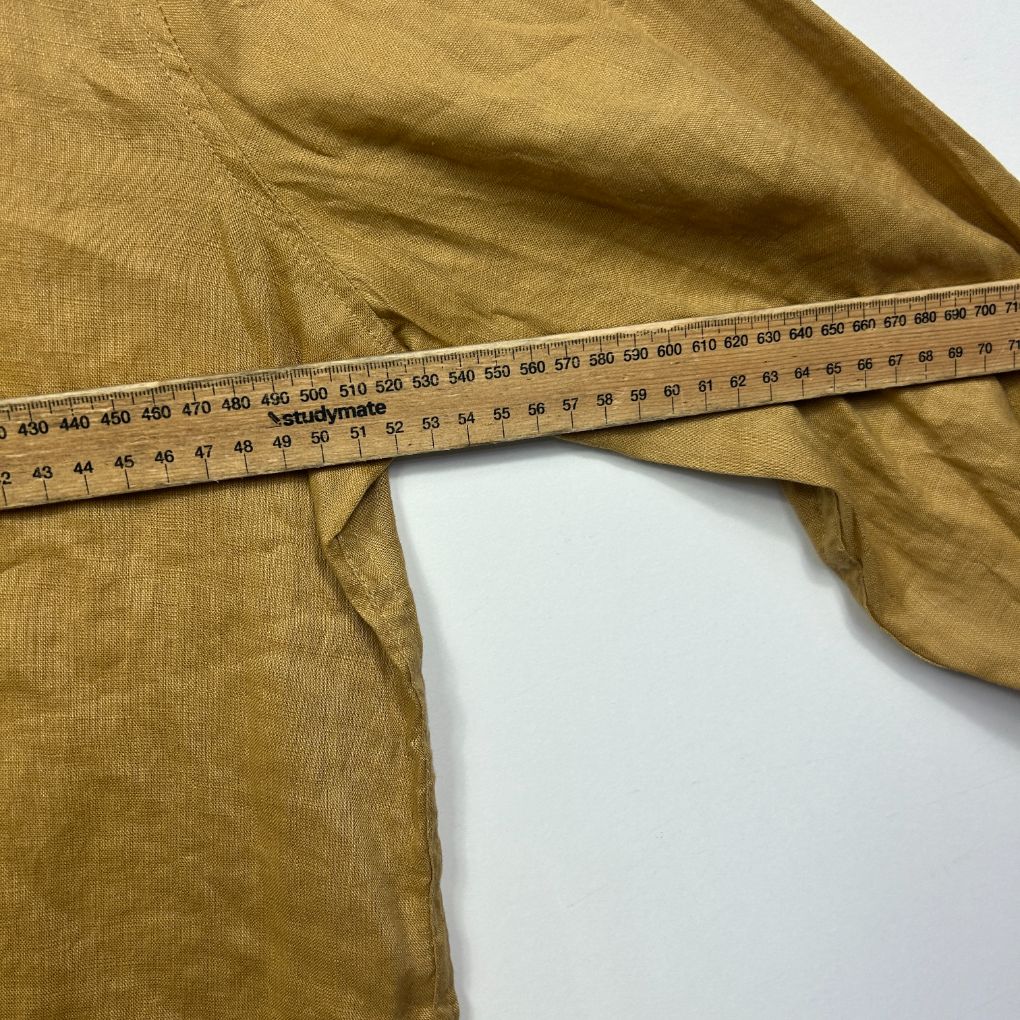Mustard yellow ribbed fabric detail view with measuring tape