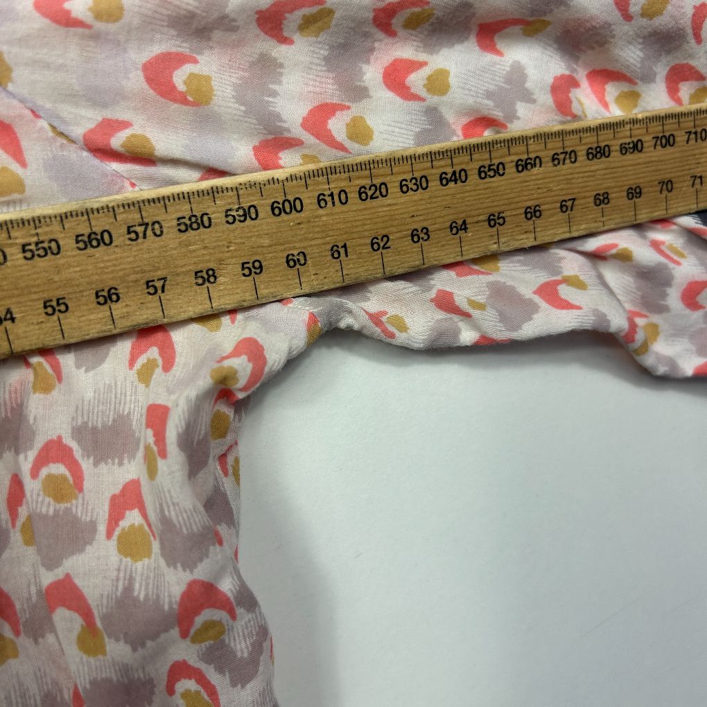 Red and yellow floral fabric detail view with measuring tape