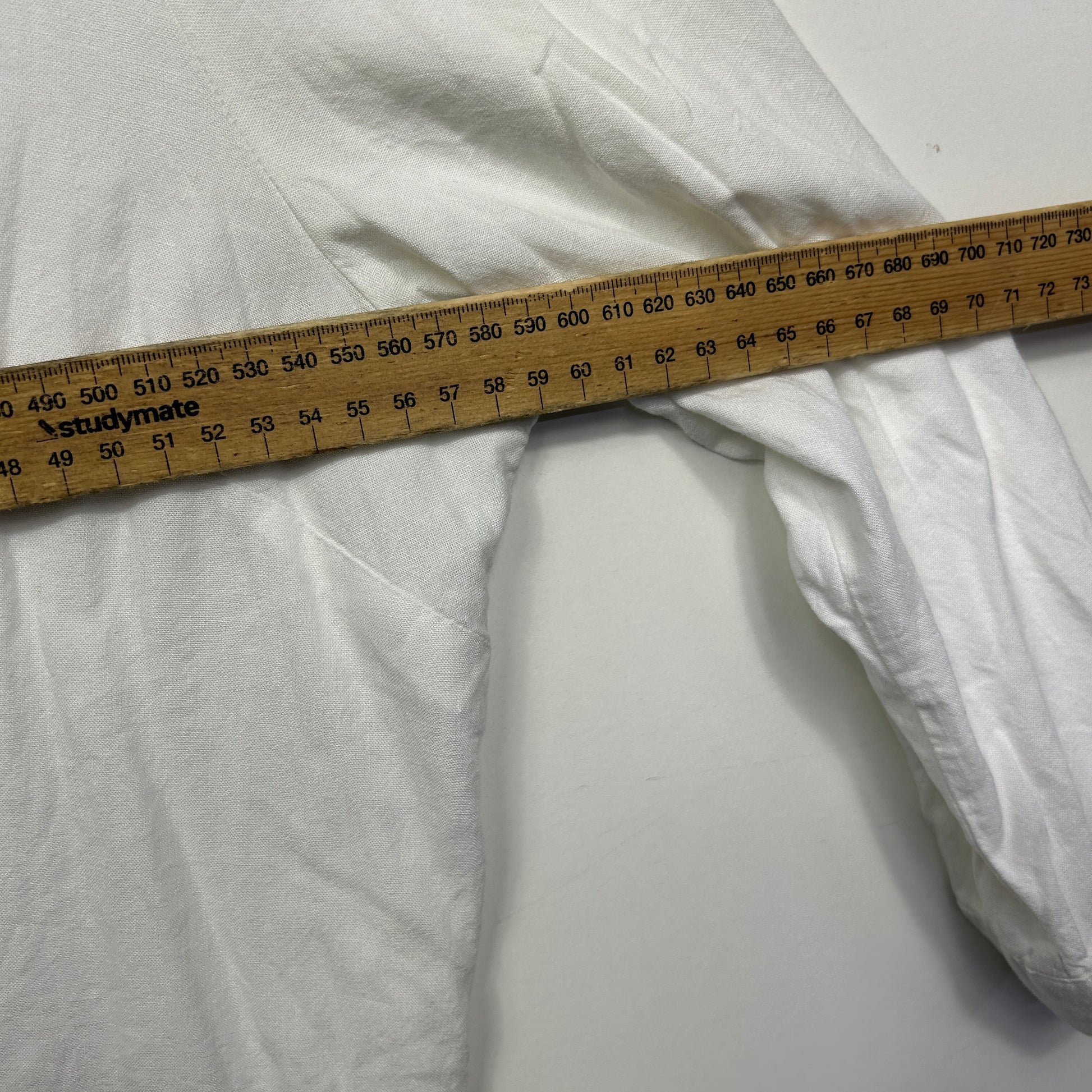 White fabric detail view with measurement tape