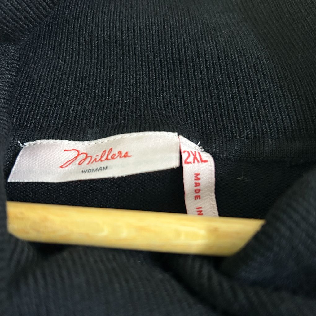 Black ribbed knit sweater label and detail view