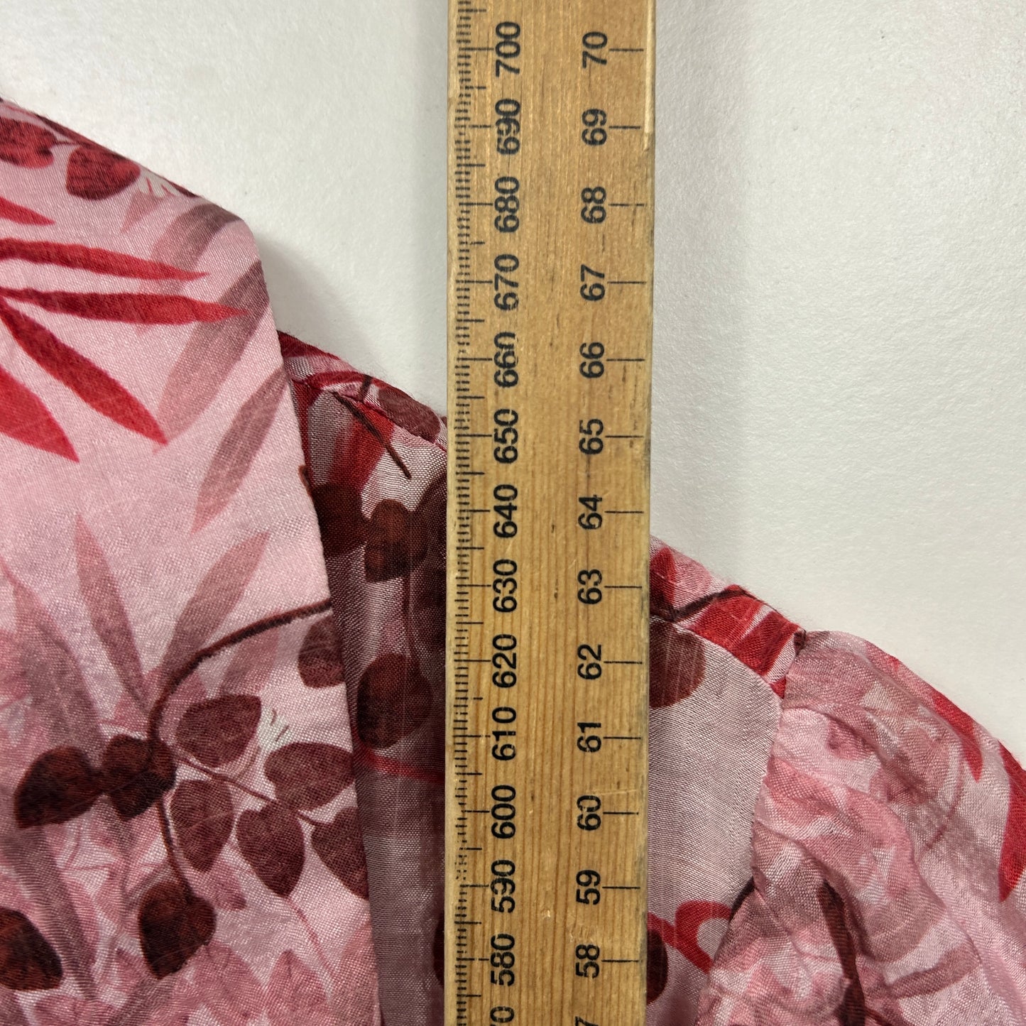 Pink floral fabric detail view with measuring ruler