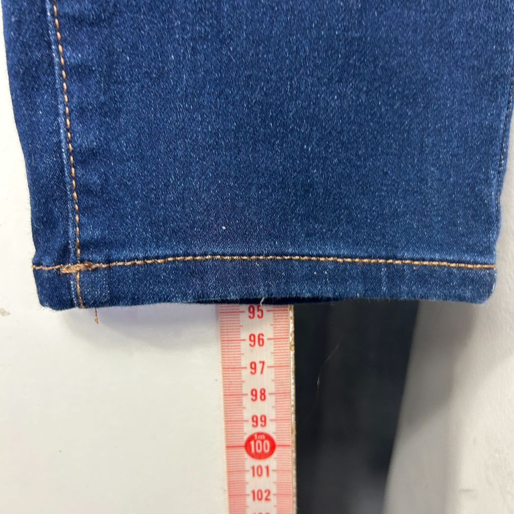 Blue denim jeans hem detail view