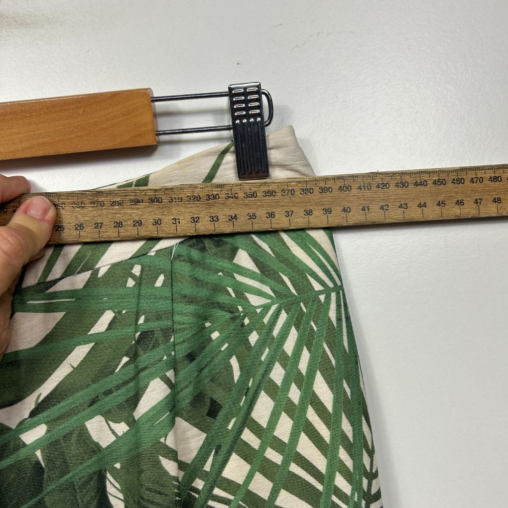Green and white patterned fabric detail view with measurement ruler
