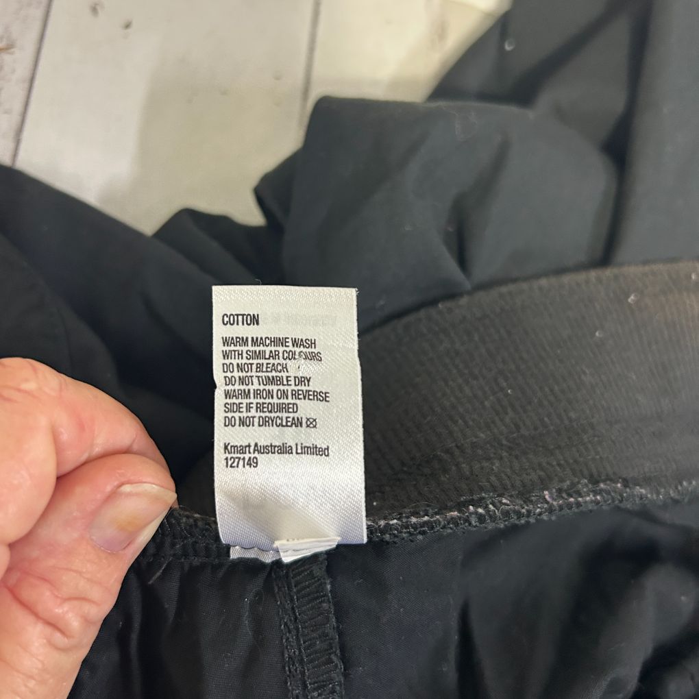 Black cotton garment label detail view