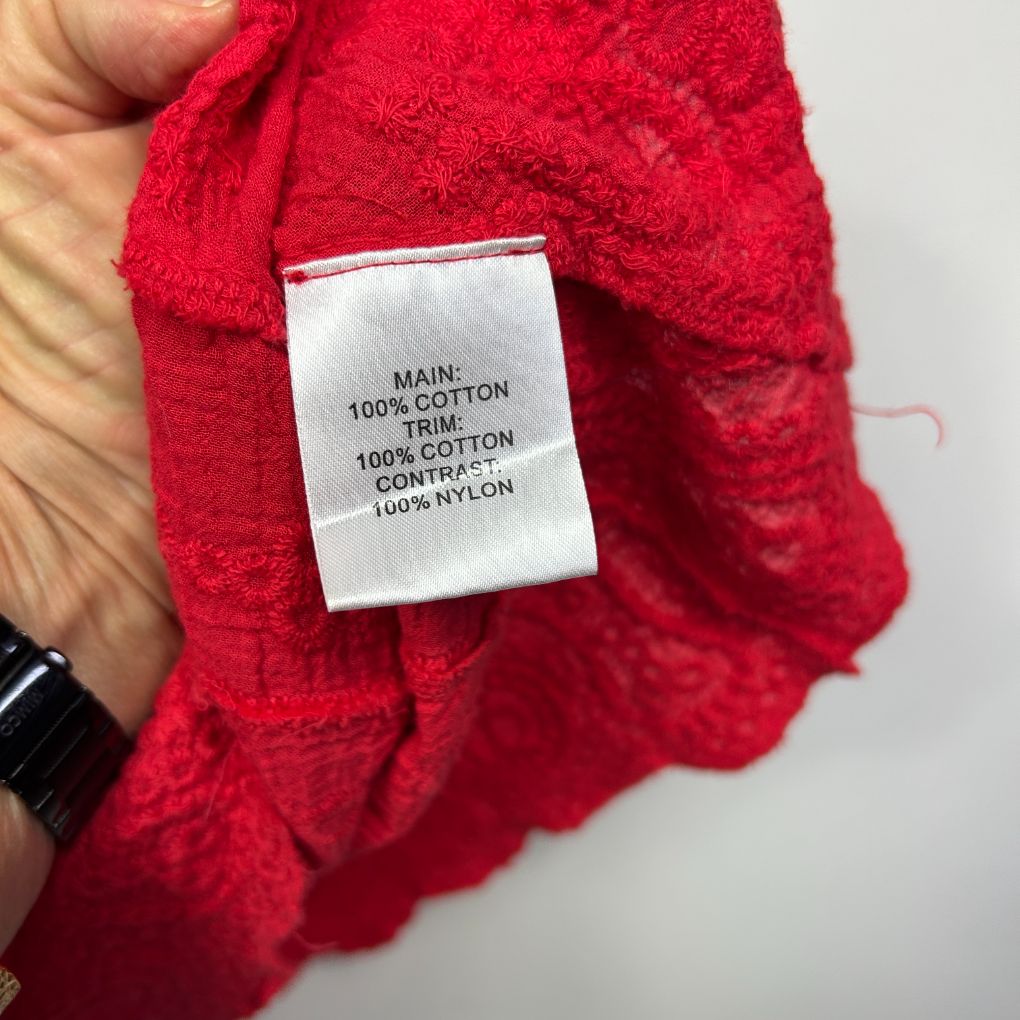 Red cotton garment label detail view