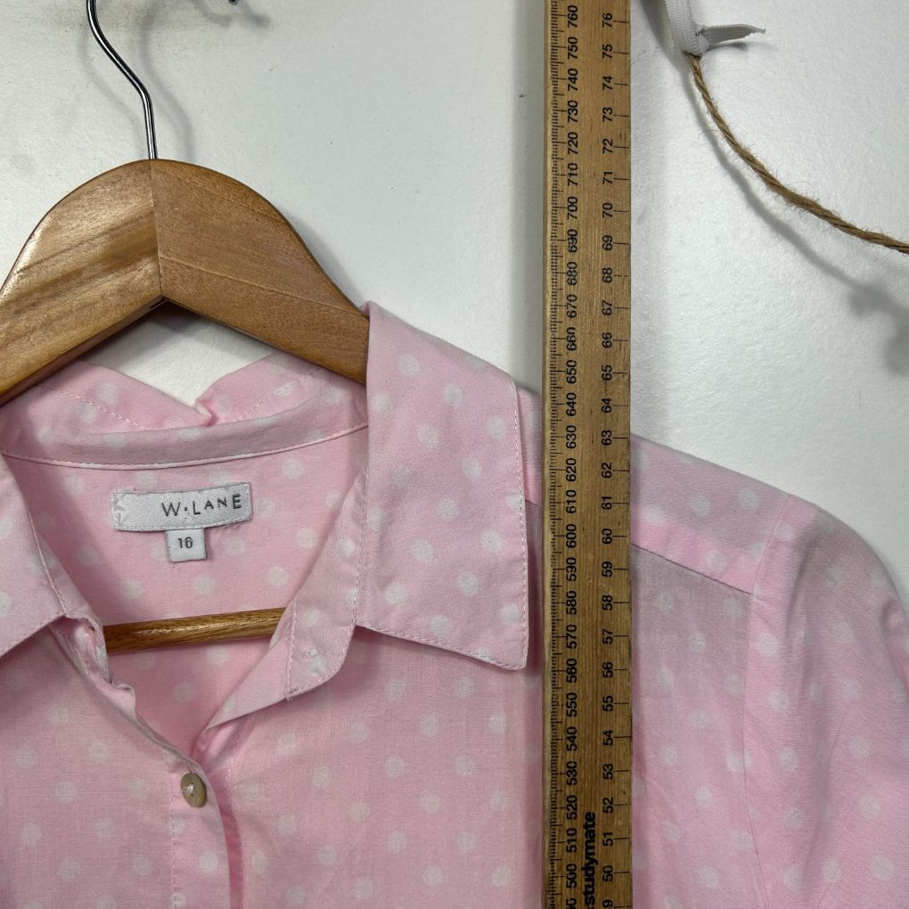 Pink shirt front view on wooden hanger with measuring tape