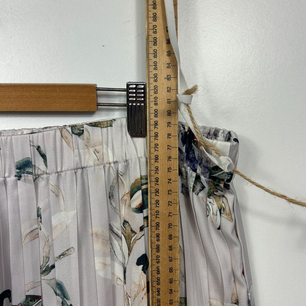 White floral print pants detail view with measuring tape