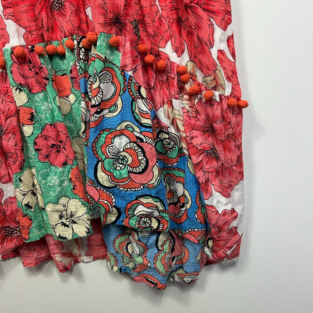 Red floral fabric with blue and multicolored embroidered detail view