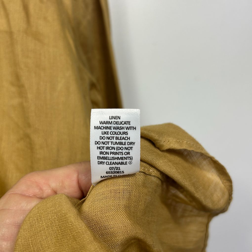 Mustard yellow jumper care label detail view
