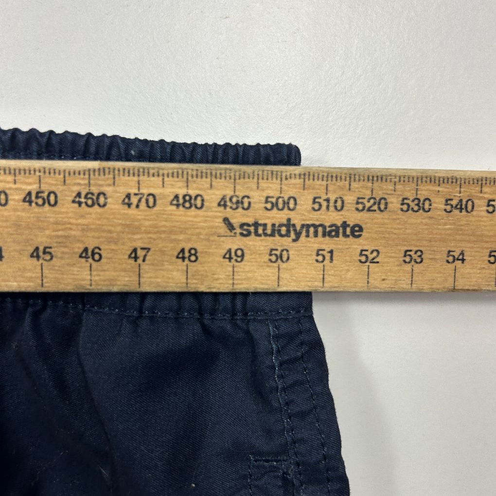 Navy shorts waistband detail view with measuring tape