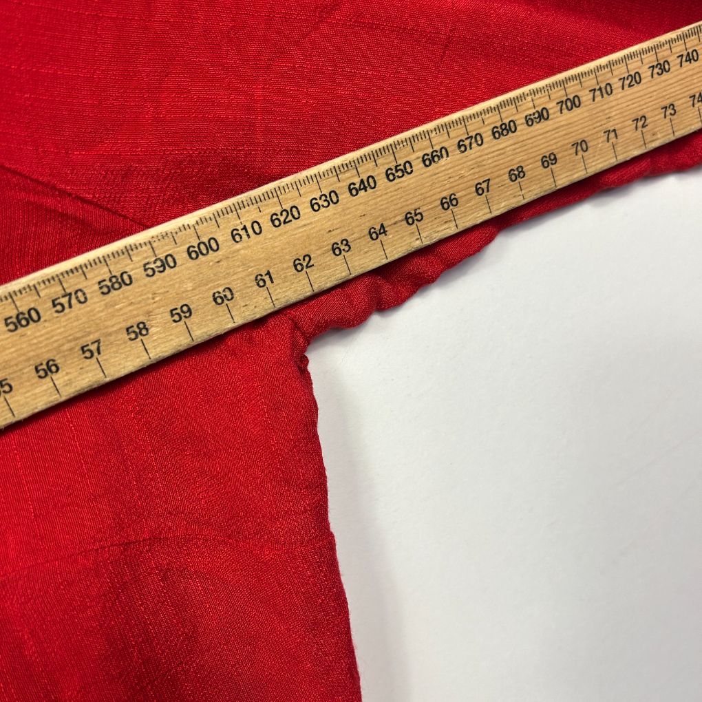 Red fabric with measuring tape detail view