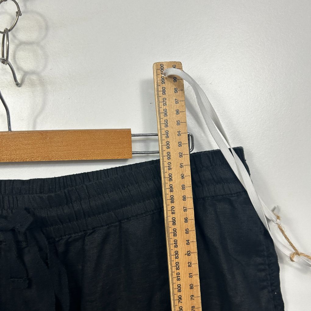 Black shorts waistband detail view with measuring tape