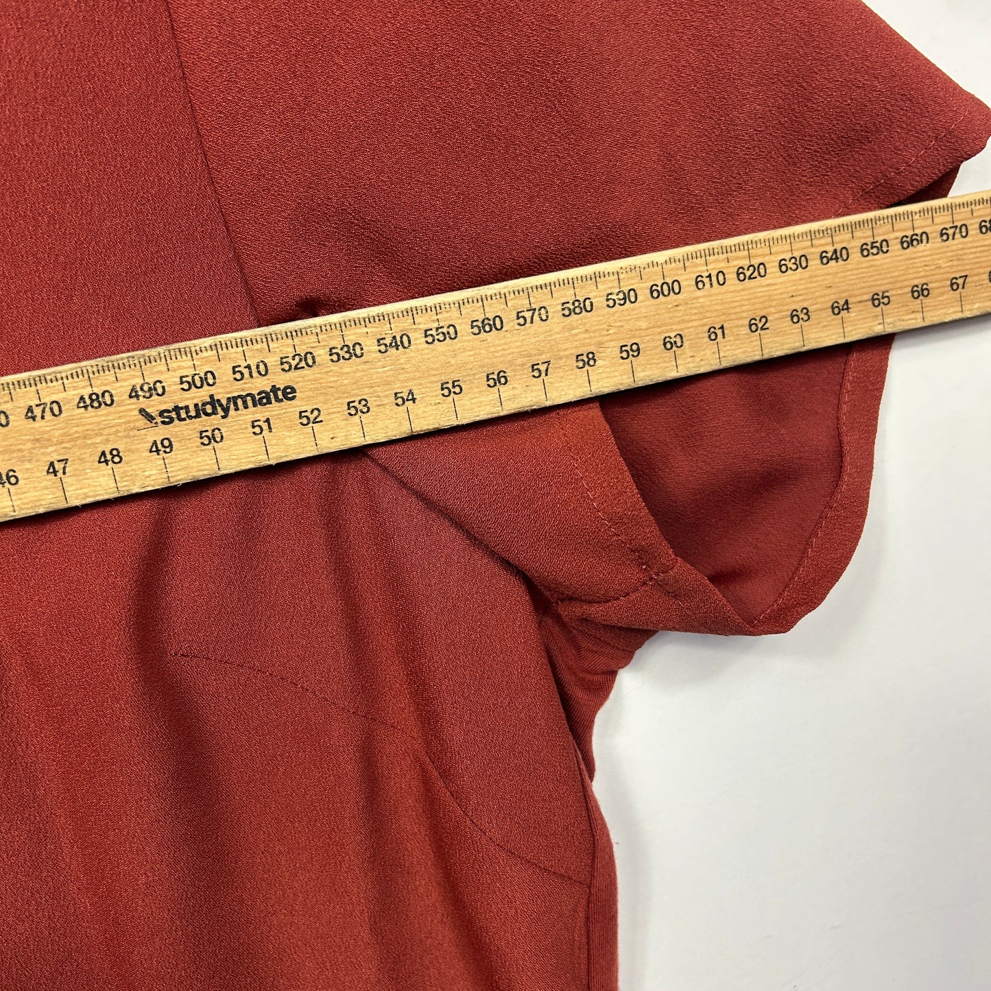 Rust red hoodie side view with measuring tape