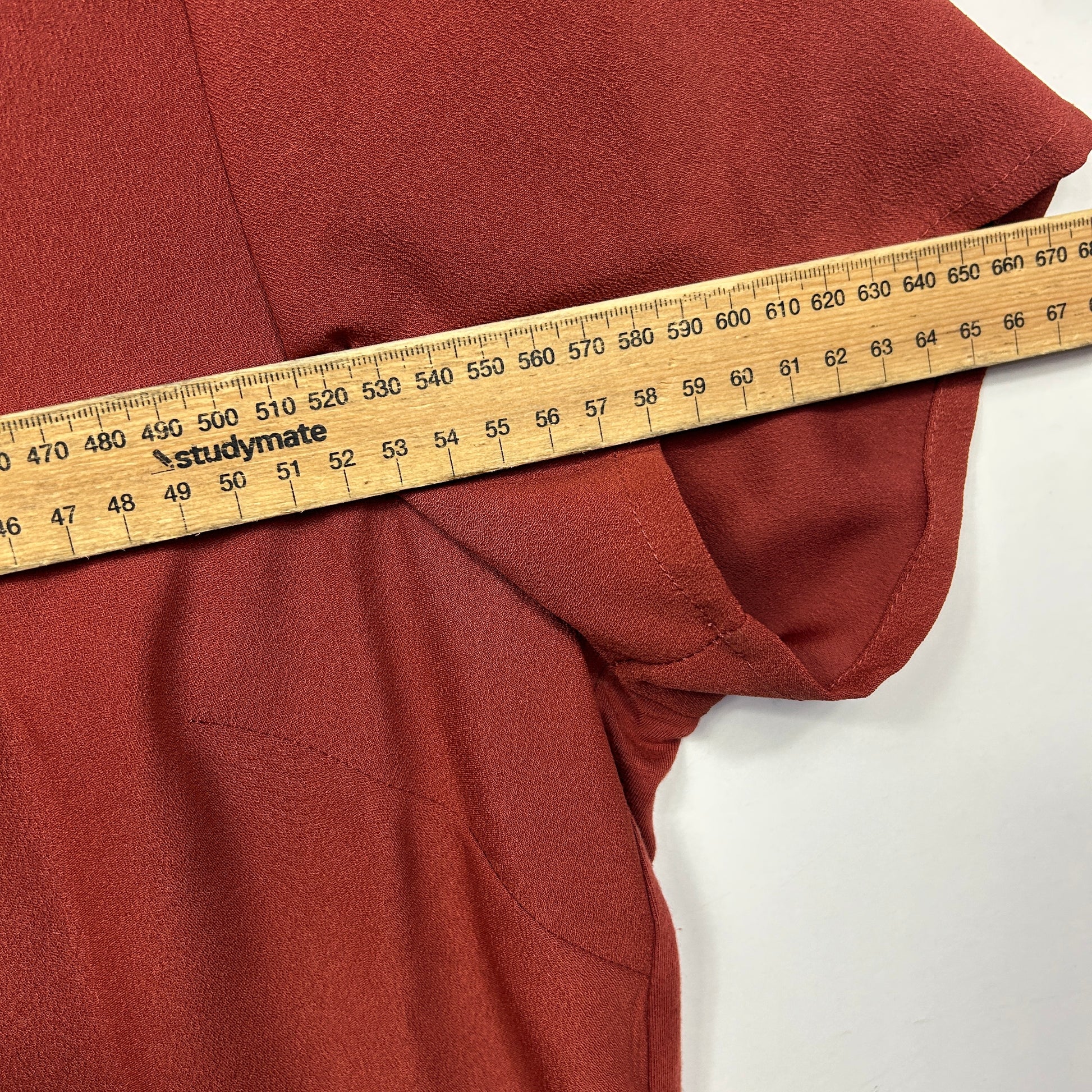 Rust red hoodie side view with measuring tape