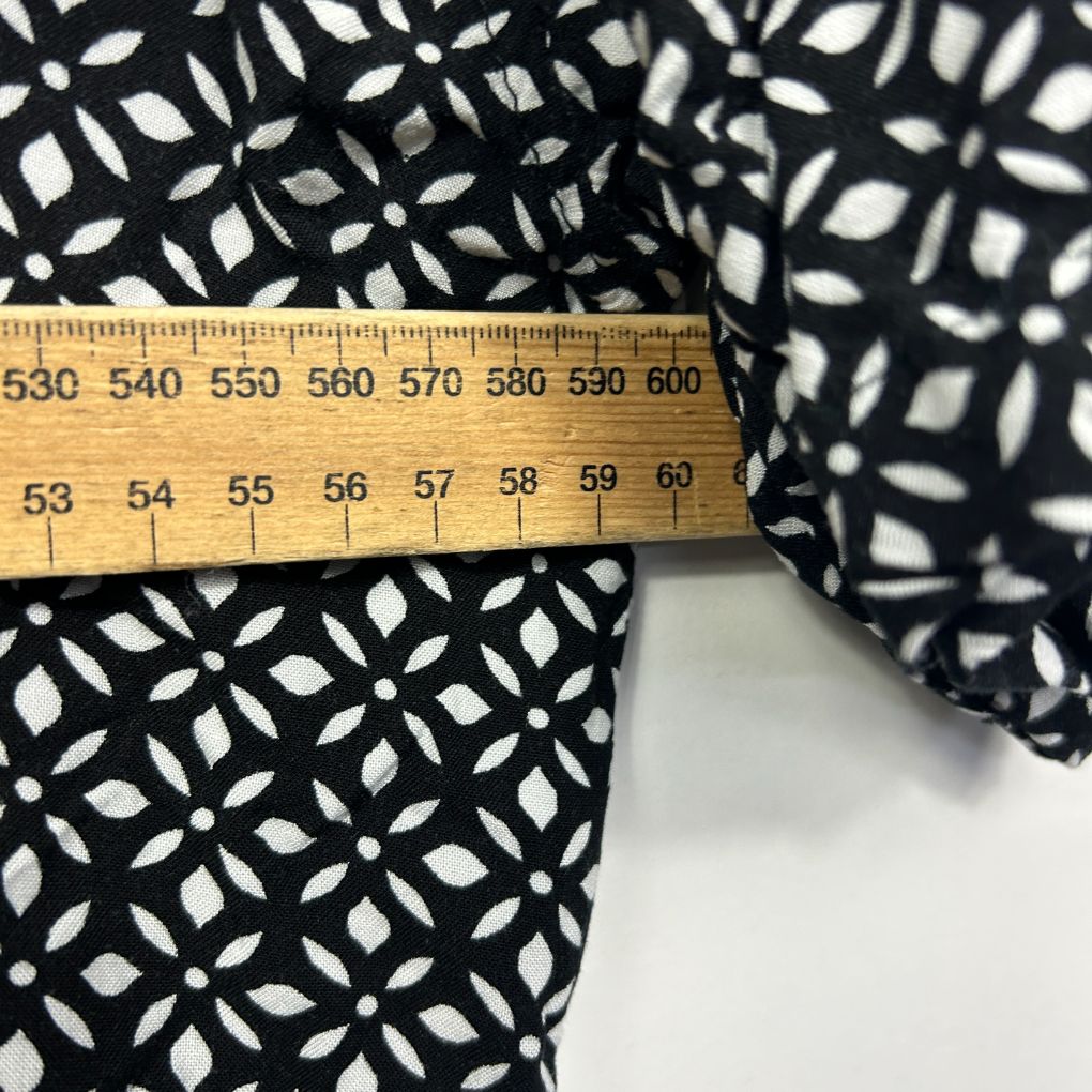 Black and white geometric patterned fabric detail view with measuring tape