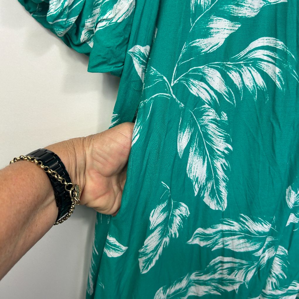 Green floral dress detail view with chain bracelet