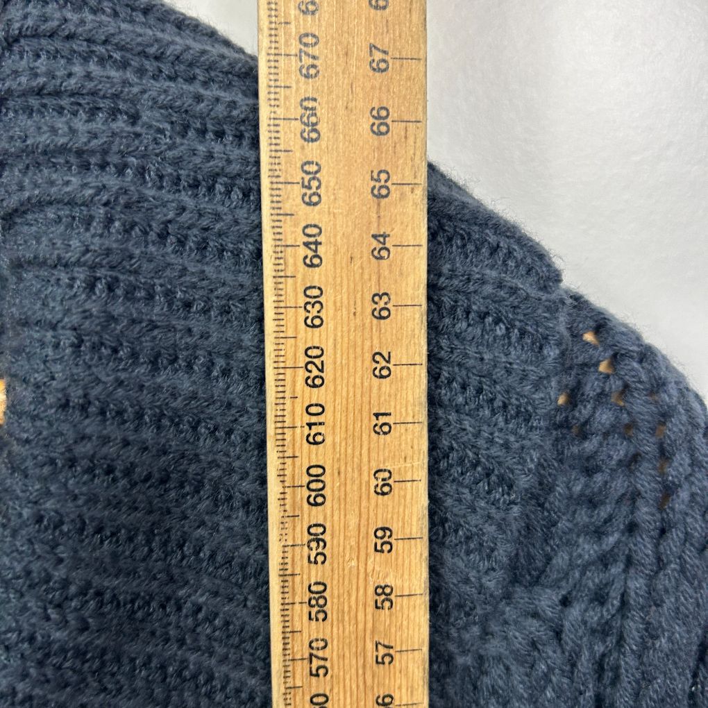 Navy knit sweater detail view with measuring tape