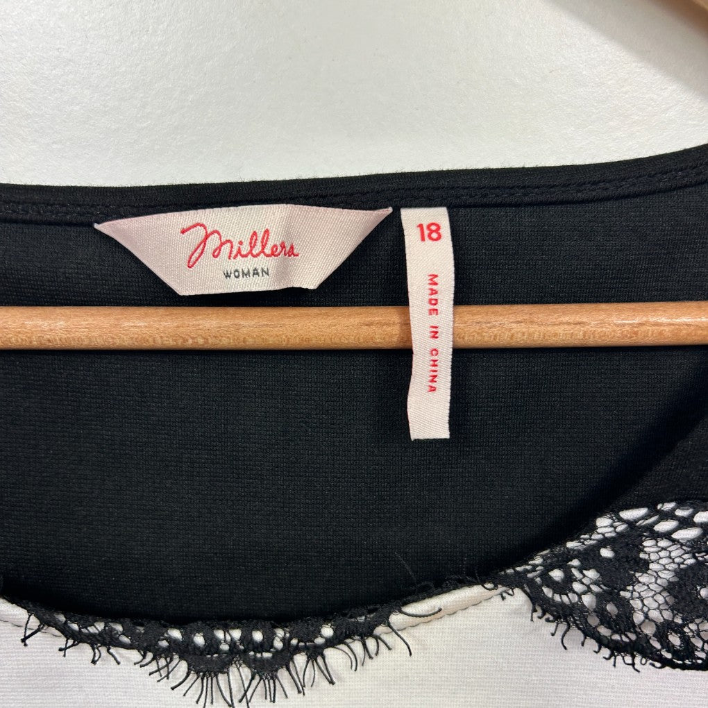 Black crop top detail view showing label and wooden hanger